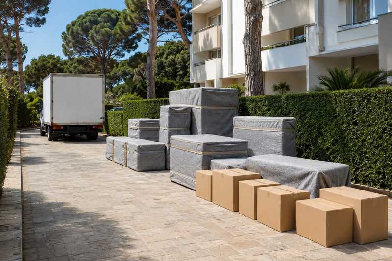 Meubles protégés et cartons dans l’allée d’une résidence à Sainte-Musse